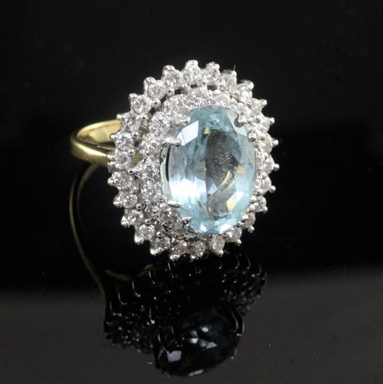 An 18ct gold, aquamarine and diamond oval dress ring, size K.